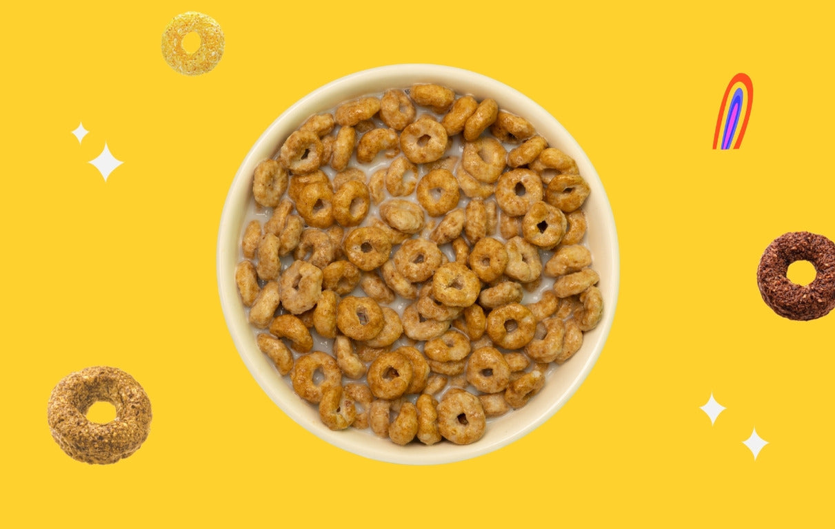 Bol de cereales en forme d’anneaux trempees dans du lait, avec un fond jaune dynamique et des elements visuels ludiques. Magic Morning, des cereales saines et proteinees, faibles en sucre et riches en fibres, pour un petit-dejeuner gourmand et equilibre.
