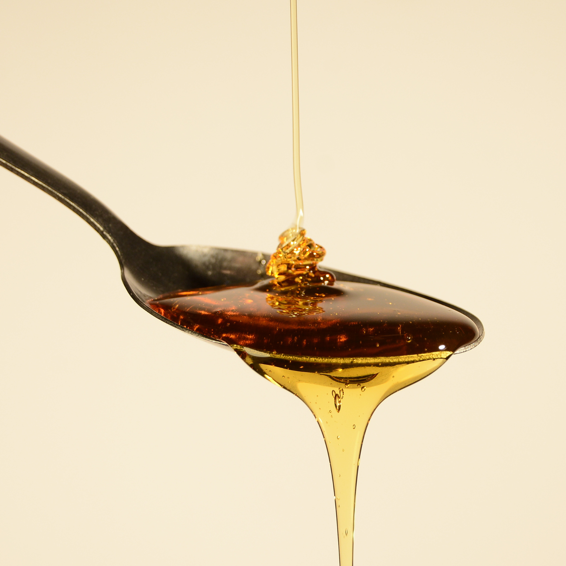 Image d'une cuillère avec du sirop d'agave qui coule représentant un des ingrédients de nos céréales riches en protéines Magic Morning